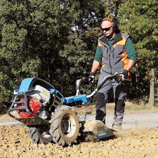 Bertolini 413 two-wheel walk-behind tractor with tiller box attachment preparing ground for plating or seeding for a garden, vineyards or orchards.